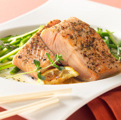 Closeup of herb covered baked tuna with a side of blanched asparagus 