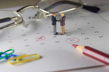 Simple Photo Illustration, Handshaking Mini Figure Businessman, Agree to doing something together at marked date