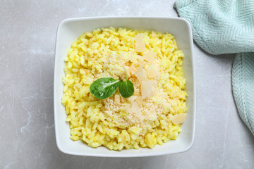 Delicious risotto with cheese on grey marble table, top view