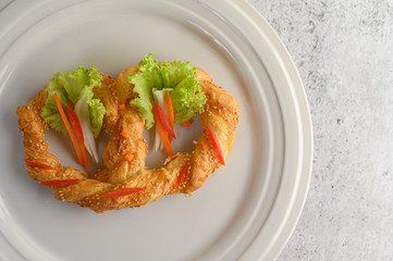 Freshly baked soft pretzel on white dish