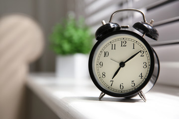 Alarm clock on windowsill, space for text. Morning time