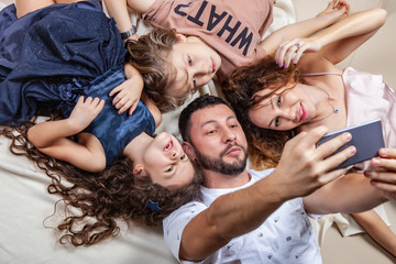 Happy family taking selfie picture with smartphone