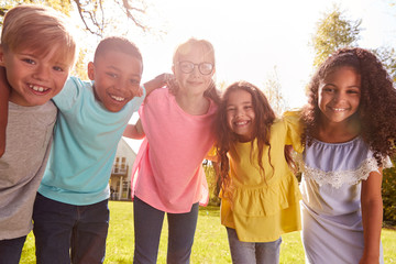 Portrait Of Smiling Children Outdoors At Home Looking Into Camera