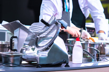 Slicer in the restaurant kitchen. Concept - Slicer washed with detergent. Detergent for kitchen appliances. Professional semi-automatic slicer. Machine with a cutting disc. Grocery Store Equipment.