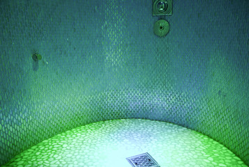 Rain shower with mood light inside spa and wellness area thermal suite on luxury cruiseship or...