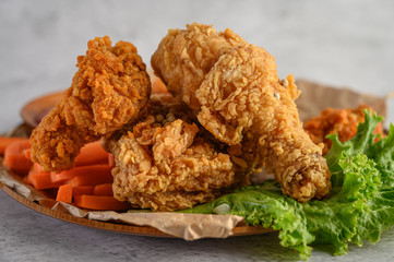 Crispy fried chicken on a plate with salad and carrot, Selective focus.