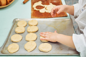 child cooks cookies in the kitchen