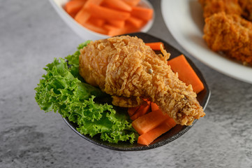 Crispy fried chicken on a plate with salad and carrot, Selective focus.
