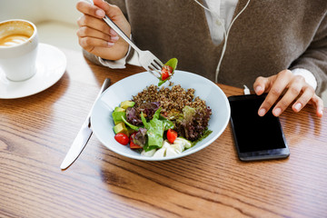 Portrait of african american woman with earphones and cellphone in cafe