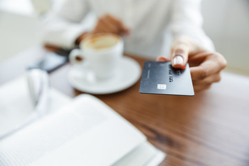 Portrait of african american woman paying in cafe with credit card