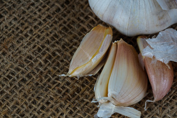 Close up of garlic cloves over brown sack background.