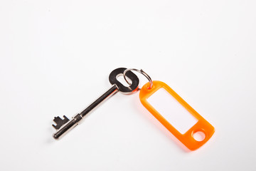Key with orange key ring tag on white background