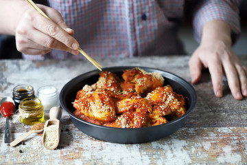 Selective focus. A man eats chicken wings with his hands. Chicken wings baked with sesame seeds. Buffalo Wings.