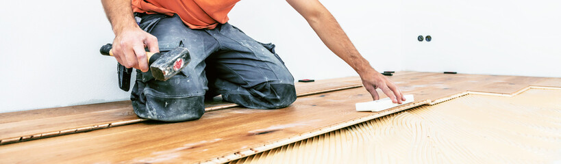 Handwerker verleget Parkett boden in einem modernen neubau Haus