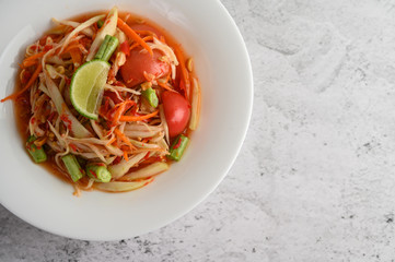Thai papaya salad in a white plate.