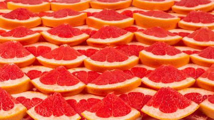 Grapefruit red juicy slices background. top view.