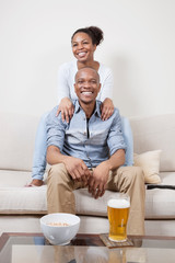 Portrait of excited young African American couple watching TV
