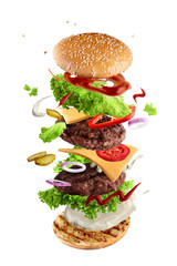 Maxi hamburger, double cheeseburger with flying ingredients isolated on white background. High resolution image