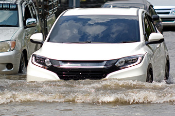 Fototapeta na wymiar more floods and flooded cars ,car driving flood water on a road