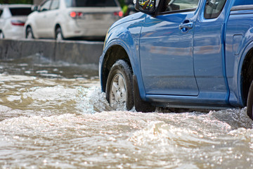 more floods and flooded cars ,car driving flood water on a road