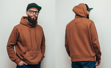 Handsome hipster guy with beard wearing brown blank hoodie or hoody from front and back and black...