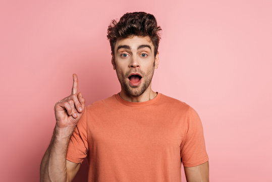 Shocked Man Showing Idea Sign While Looking At Camera On Pink Background