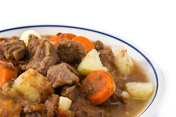 Irish beef stew with carrots and potatoes isolated on white background