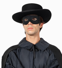 Thoughtful young man dressed as Zorro against gray background