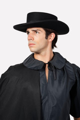 Fototapeta na wymiar Thoughtful man dressed as Zorro against gray background