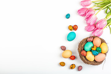 Fototapeta na wymiar Stylish background with colorful quail, easter eggs with copy space for text. Next lying fresh pink tulip flowers. isolated on white background. Flat lay, top view, mockup, overhead, template