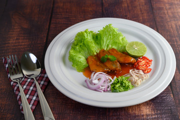 Spicy salad of sardine with tomato sauce in white dish