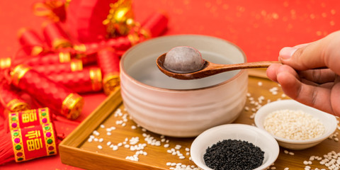 Chinese Lantern Festival traditional food black sesame dumplings on red background