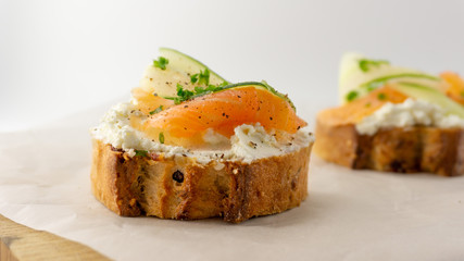 Salmon sandwich with french baguette, soft cheese cream, cucumber and persil. On a white background, isolated 