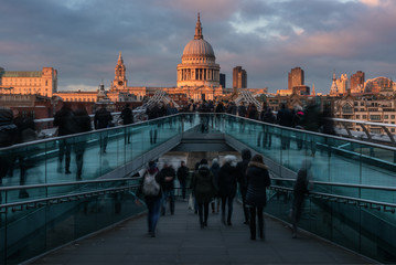 St. Paul's Cathedral and Millennium Bridge with people movement during twilight, London, UK