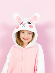 pretty blonde girl with cozy rabbit costume is posing in the studio and is happy