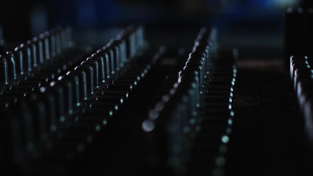 lines of numerous metal t-shaped pipe joints on wooden desk