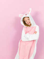 pretty blonde girl with cozy rabbit costume is posing in the studio and is happy