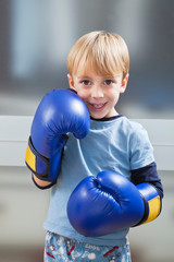 Portrait of Caucasian boy in casuals wearing boxing gloves