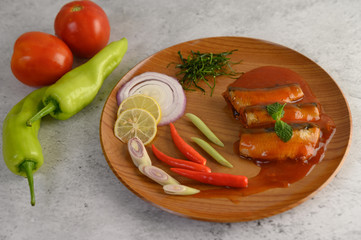 Spicy salad of sardine in tomato sauce on wooden tray