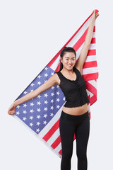 Portrait of smiling young woman holding American flag over white background