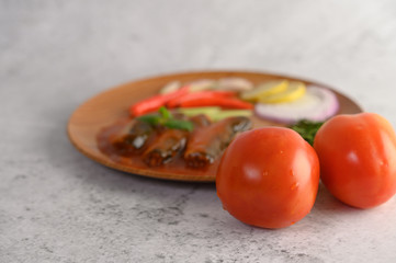 Spicy salad of sardine in tomato sauce on wooden tray