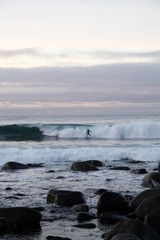 Obraz premium Surfer ride a wave in Unstad beach area which is known as an arctic surfing center located in Lofoten Islands in Northern Norway. 
