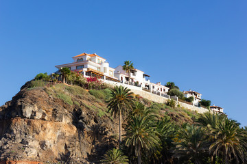 Fototapeta na wymiar Fancy mansion on hill top in Agaete, Gran Canaria. Big house on cliff edge in Canary Islands, Spain. Wealthy property, real estate concepts