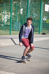Fototapeta premium Young man skateboarding on road