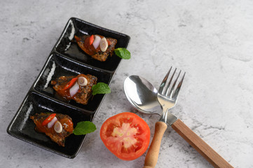 The spicy sardine in ceramic tray