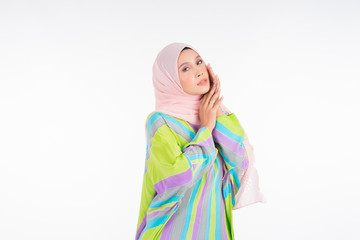 Beautiful female model wearing a pastel batik kaftan/caftan, a traditional dress for Muslim women isolated over white background. Stylish Muslim female hijab fashion lifestyle portraiture concept.