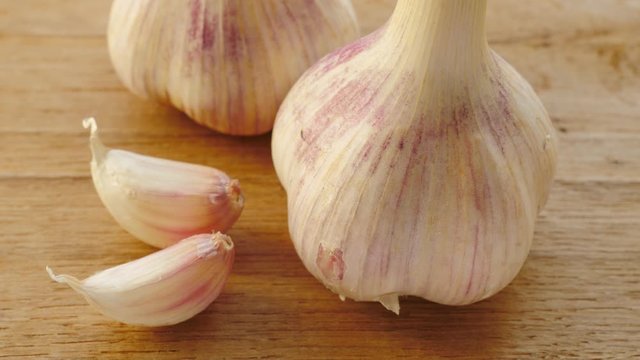 Close up of garlic bulb and clove on wooden rustic board. Healthy eating, aromatic spice