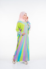 Beautiful female model wearing a pastel batik kaftan/caftan, a traditional dress for Muslim women isolated over white background. Stylish Muslim female hijab fashion lifestyle portraiture concept.