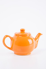 Close-up of orange kettle over white background