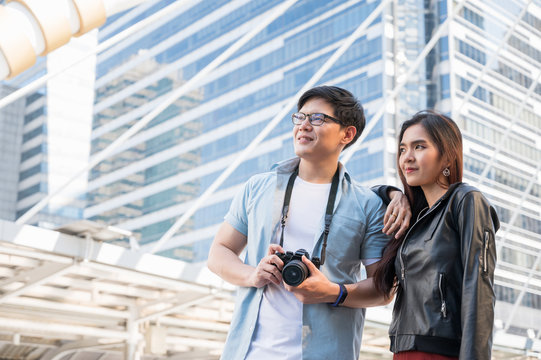 Asian couple tourist looking forward and travel in urban city.